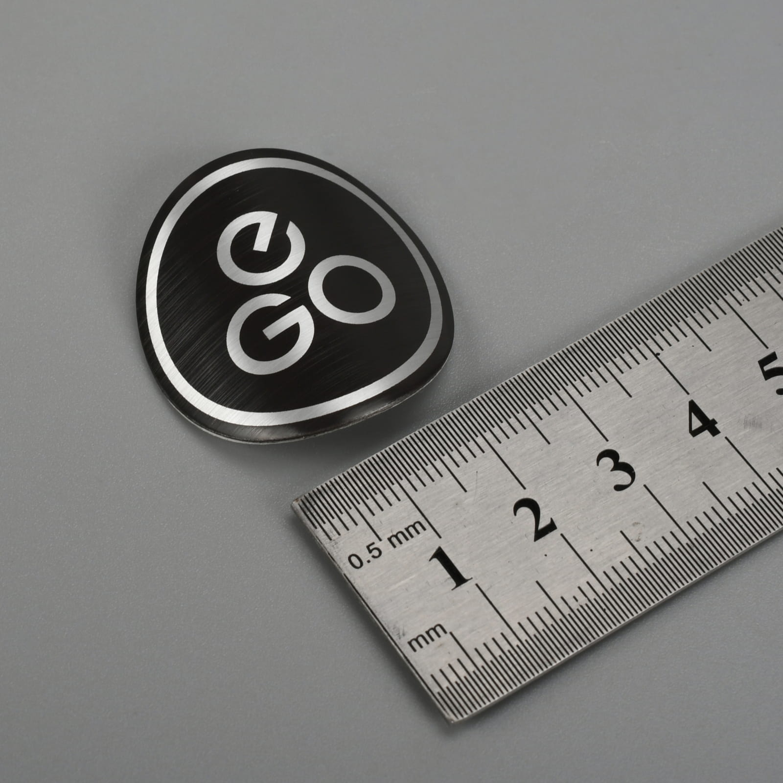Logotypskylt i präglad metall